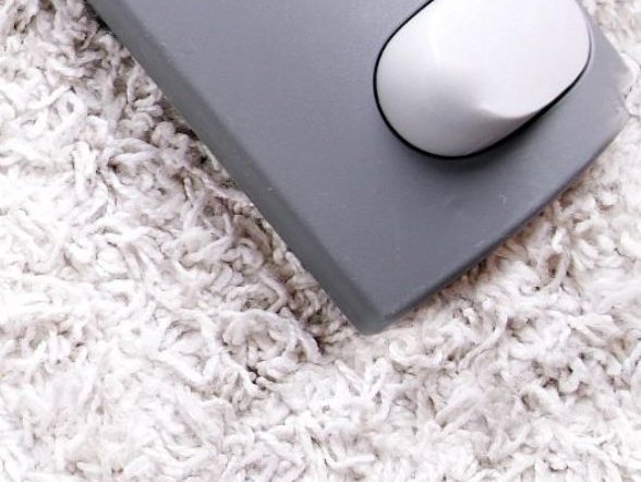 Vacuuming a white carpet from Elite Flooring on Olyphant, PA